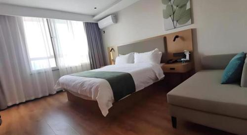 a hotel room with a bed and a couch at Green Tree Inn Luoyang Fenghuang Mansion Mudan Square Metro Station in Luoyang