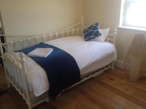 a bed with blue and white sheets and a window at 5 bedroom Town House in Dungarvan