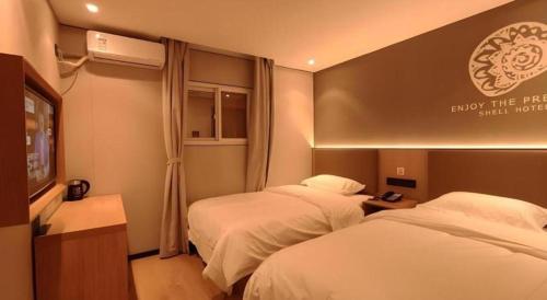 a hotel room with two beds and a television at Shell Hotel Beijing Shunyi District Shunyi Metro Station in Beijing
