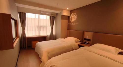 a hotel room with two beds and a window at Shell Hotel Beijing Shunyi District Shunyi Metro Station in Beijing