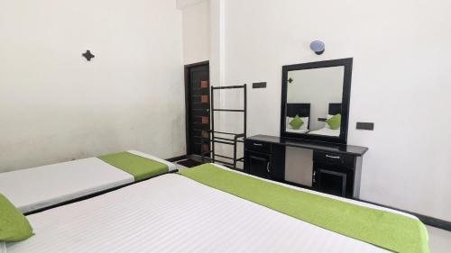 a bedroom with two beds and a mirror at The Village - Ella in Bandarawela