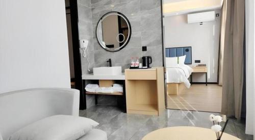 a bathroom with a bed and a sink and a mirror at GreenTree Inn Express Qingdao Jiaodong International Airport in Qingdao