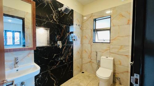 a bathroom with a toilet and a sink at Away From Home - 8 - HomeStay, Entire 2 BHK Villa in Ooty