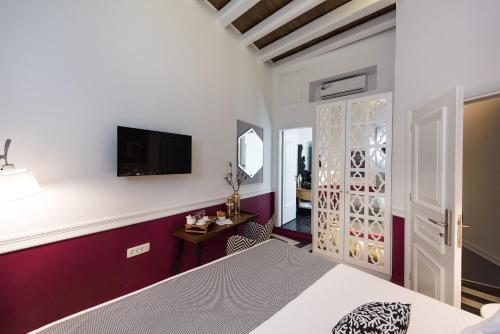 sypialnia z łóżkiem i telewizorem na ścianie w obiekcie Elia Portou Due w Chanii