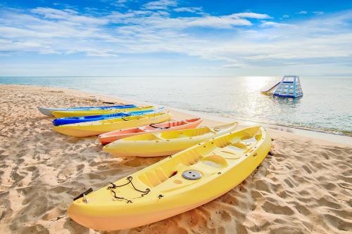a group of kayaks lined up on a beach at Mercury Phu Quoc Resort & Villas in Phu Quoc
