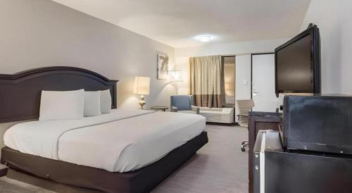 a hotel room with a bed and a television at Rodeway Inn Lumberton Central in Lumberton