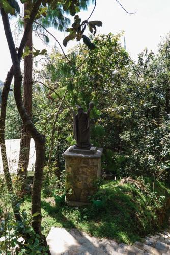 a statue of a man sitting on a stone pillar at Find Your Perfect Mountain Retreat at House fire 