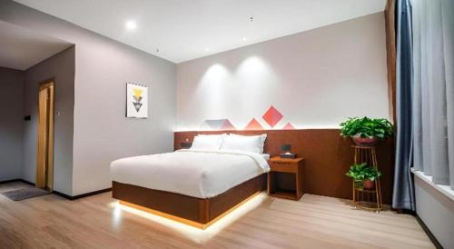 a bedroom with a large bed in a room at Borrman Hotel Changzhi Medical College Wulong Campus High-speed Railway South Station in Changzhi