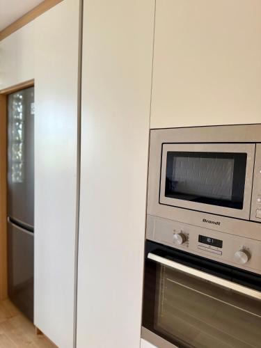 a kitchen with a microwave and a refrigerator at Perle au centre ville avec vue mer et montagne in Saint-Denis
