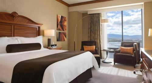 a hotel room with a bed and a large window at Atlantis Casino Resort Spa in Reno