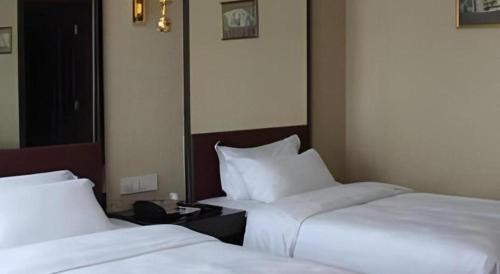 two beds sitting next to each other in a room at Milu Hotel in Guangzhou