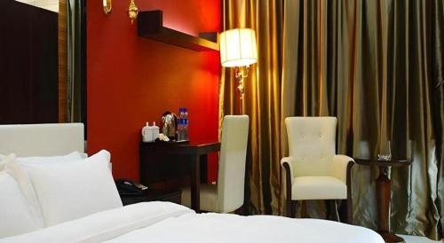 a bedroom with a bed and a desk and a chair at Milu Hotel in Guangzhou