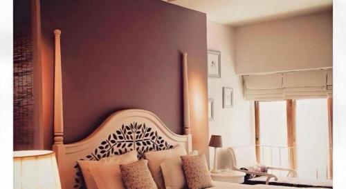 a bedroom with a bed with a wooden head board at Baan Hmon-Oon in Chiang Mai