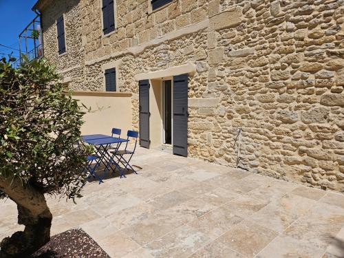 a patio with a table and a building at Appartement - mas provençal in Sernhac