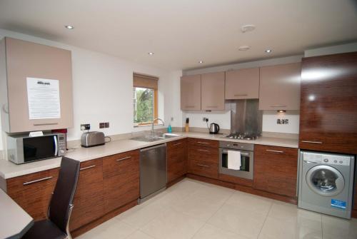 a kitchen with wooden cabinets and stainless steel appliances at Southampton Serviced Apartments in Southampton