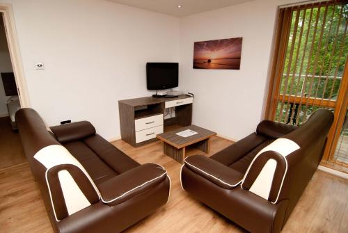 a living room with two leather chairs and a television at Southampton Serviced Apartments in Southampton