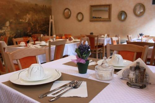 a dining room with tables with white plates and silverware at Hotel Berr in Sarajevo