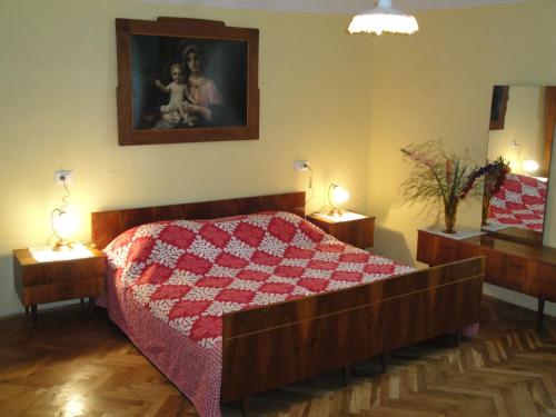 1 dormitorio con 1 cama con edredón rojo y blanco en Authentic traditional Soca Valley home, en Kanal
