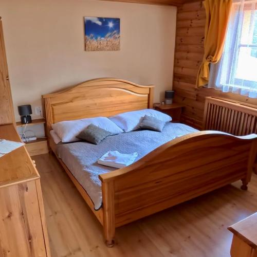 a bedroom with a wooden bed in a room at Penzion UNA in Liptovský Ján