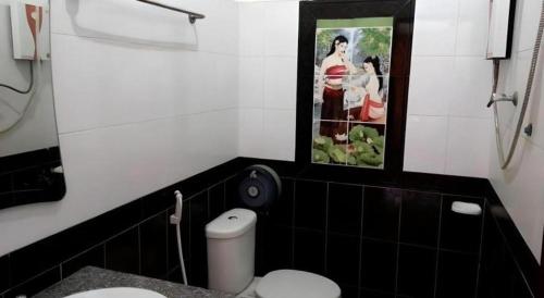 a bathroom with a toilet and a picture on the wall at Khamsaner Hotel in Vientiane