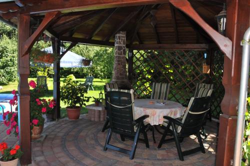 a patio with a table and chairs under a pergola at Land-Hotel Am Wald Garni in Greiz