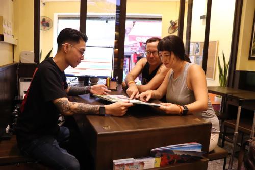a group of people sitting at a table at Rebel Rooster Hostel in Hanoi