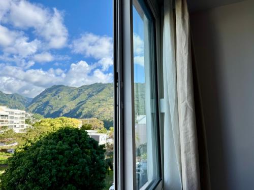 a window with a view of a mountain at Perle au centre ville avec vue mer et montagne in Saint-Denis