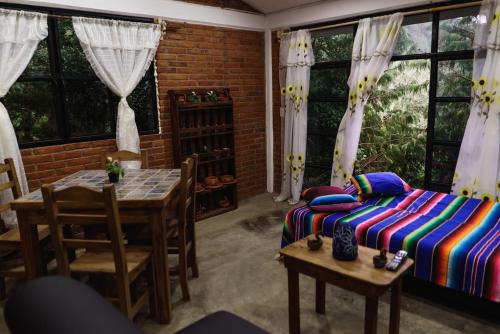 a bedroom with a bed and a table and windows at Find Your Perfect Mountain Retreat at House Sun 