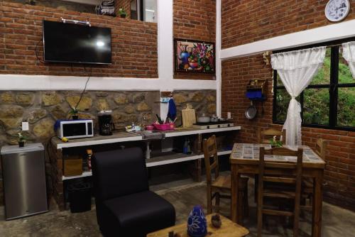 a room with a brick wall with a table and a television at Find Your Perfect Mountain Retreat at House Sun 