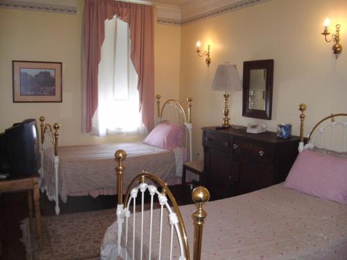 1 dormitorio con 2 camas y ventana en Leesburg Colonial Inn, en Leesburg