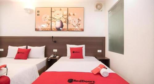 a hotel room with two beds with red pillows at Ha Noi Vang Hotel Hoang Ngan in Hanoi