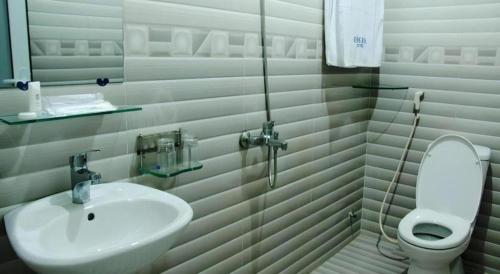 a white bathroom with a sink and a toilet at Huong Binh Hotel in Da Nang
