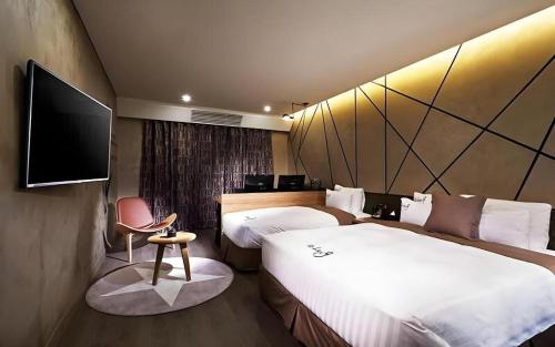 a hotel room with two beds and a flat screen tv at Hotel Boutique 9 in Seoul