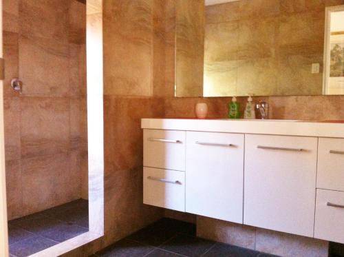 a bathroom with a white sink and a shower at Mt Lawley Garden Apartment in Perth