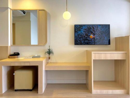 a bathroom with a vanity with a sink and a mirror at Bangsaen Villa Hotel in Si Racha