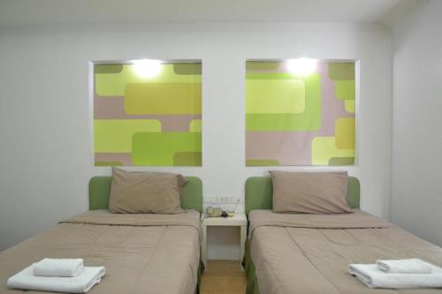 two beds sitting next to each other in a room at Bangsaen Villa Hotel in Si Racha
