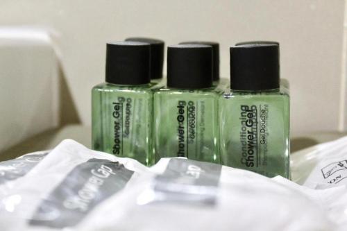 three green bottles sitting on top of a table at Bangsaen Villa Hotel in Si Racha
