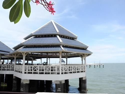 a pavilion on the water next to the ocean at Bangsaen Villa Hotel in Si Racha