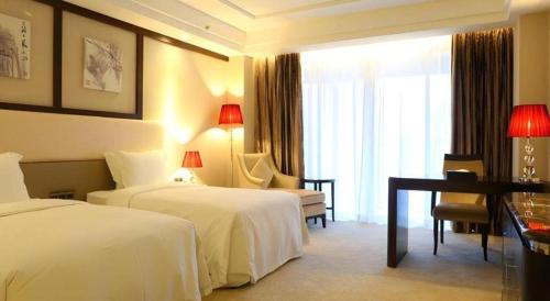 a hotel room with two beds and a desk at SUN Yat-sen university Hotel and Conference Centre in Guangzhou