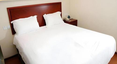 a large white bed in a room with a telephone at GreenTree Inn Beijing East Yizhuang District Second Kechuang Street Express Hotel in Beijing