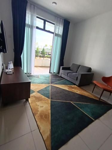 a living room with a couch and a large window at Ainur's Homestay Desaru 2 in Bandar Penawar