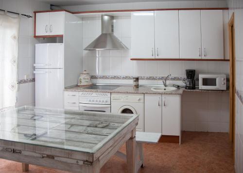 a kitchen with white cabinets and a counter top at Casa Rural Marchena in Navahermosa