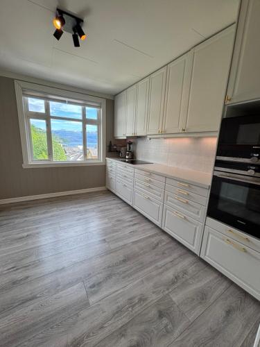 Una cocina con gabinetes blancos y una ventana grande. en Penthouse in the city center, en Kvam