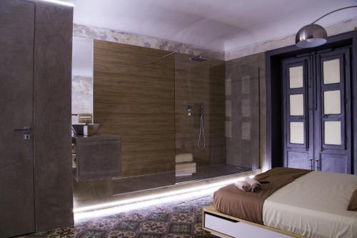 a bedroom with a shower and a bed and a tub at Community Rooms & Wine in Favara
