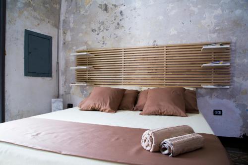 a bedroom with a large bed with two towels on it at Community Rooms & Wine in Favara