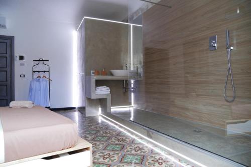 a bathroom with a shower and a bed and a sink at Community Rooms & Wine in Favara