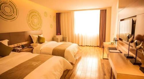 a hotel room with two beds and a window at GreenTree Inn Xi'an Yanta District Dayanta Furongyuan Hotel in Xi'an
