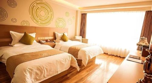 a hotel room with two beds and a window at GreenTree Inn Xi'an Yanta District Dayanta Furongyuan Hotel in Xi'an