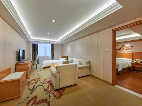 a hotel room with two beds and a living room at Vienna Hotel Xi'an Zhonglou in Xi'an
