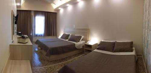 a hotel room with two beds and a television at Anetis Hotel in Tsilivi